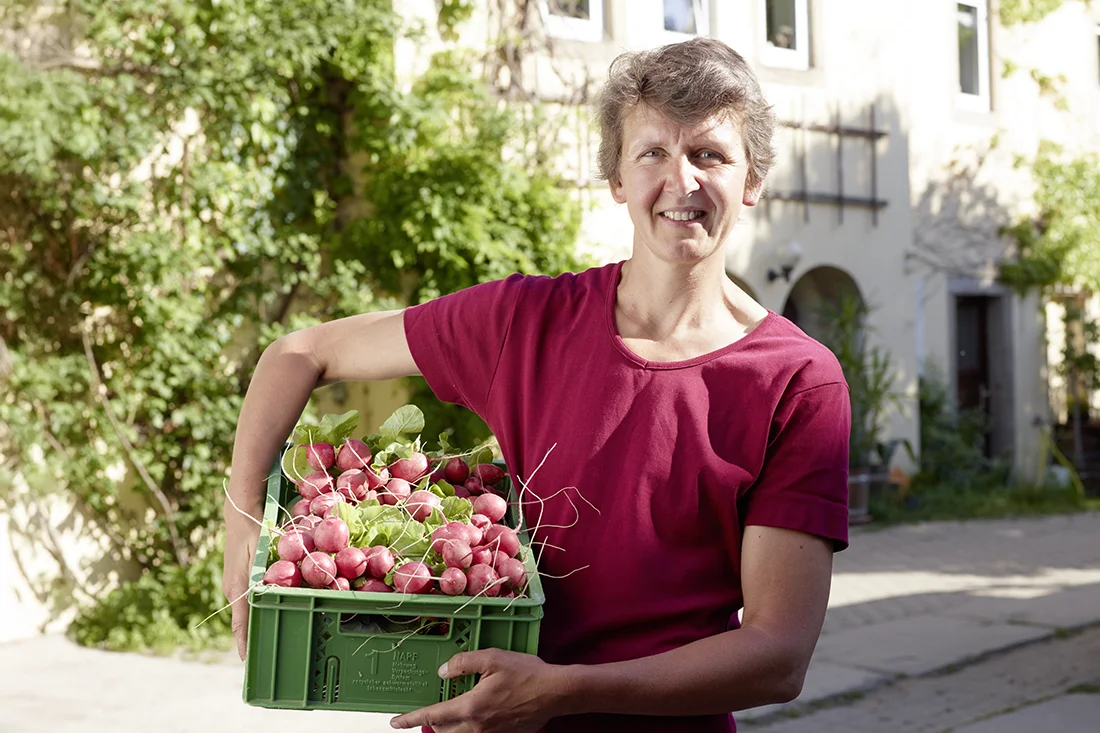 Ines Franz vor ihrem Hof mit einer Kiste Radieschen
